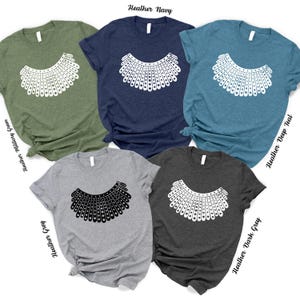 a collection of six t-shirts, each with a unique design and color, arranged in a grid-like pattern.
