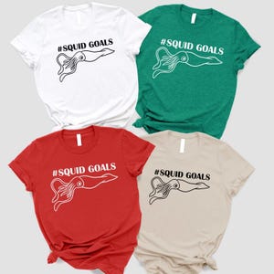 four t-shirts with the same design, featuring an octopus and the text "# SQUID GOALS" printed on them.