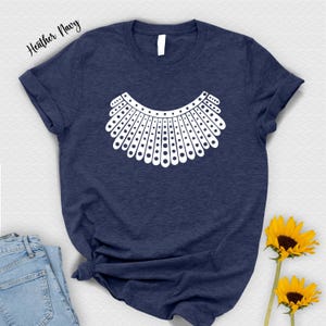 a navy blue t-shirt with a white graphic design, a pair of blue jeans, and two yellow sunflowers.