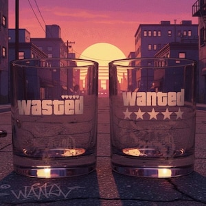 May include: Two clear glass tumblers featuring etched designs. The left glass displays the word "wasted" with five small heart icons above it. The right glass features the word "wanted" with five star icons positioned directly below the text.