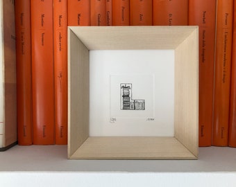 May include: A framed black and white illustration of the letter L made from stacked books. The illustration is signed and numbered 3/100.