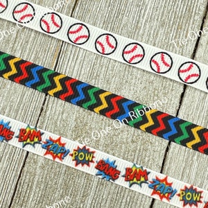 May include: Three white ribbon spools with different designs. The top spool has a repeating pattern of baseballs. The middle spool has a black and yellow chevron pattern. The bottom spool has a repeating pattern of colorful comic book sound effects like "BAM", "POW", and "ZAP!"