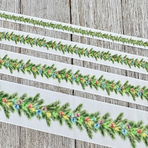 May include: White ribbon featuring a festive Christmas garland design. The garland is composed of green pine branches and colorful string lights. The ribbon is available in various widths, perfect for holiday crafts and decorations.