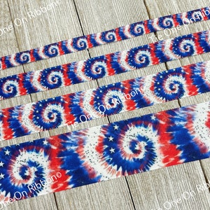 May include: Four rolls of red, white, and blue tie-dye ribbon with white stars. The ribbon has a swirl pattern.