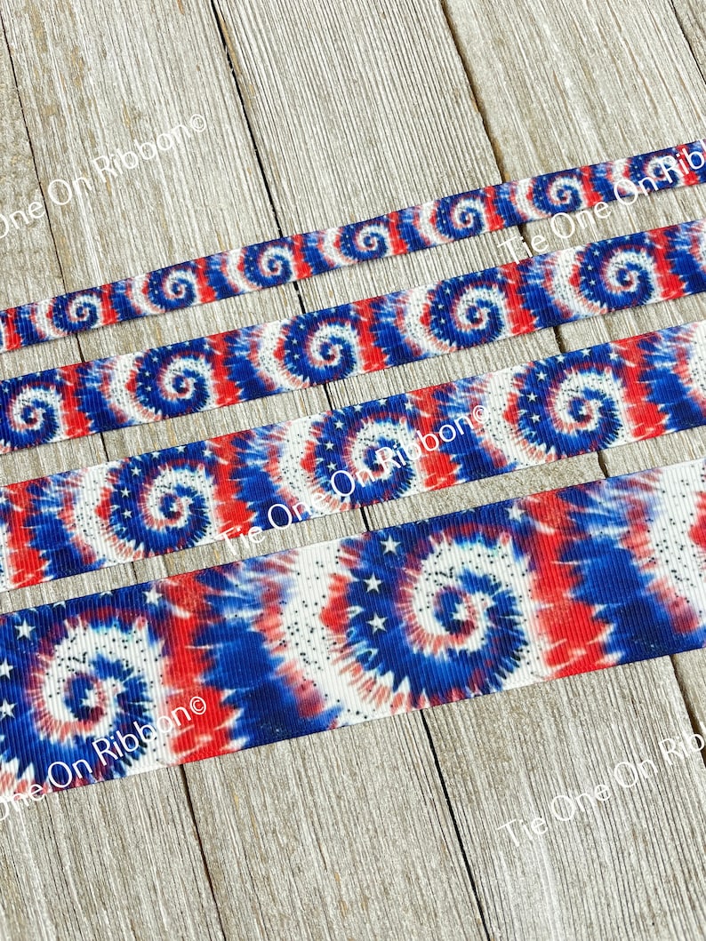 May include: Four rolls of red, white, and blue tie-dye ribbon with white stars. The ribbon has a swirl pattern.