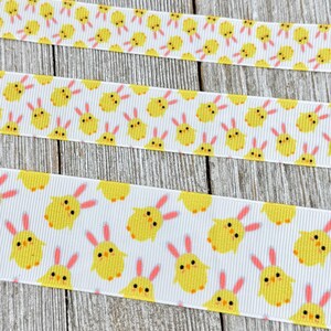 May include: White ribbon with a repeating pattern of yellow chicks with pink bunny ears.