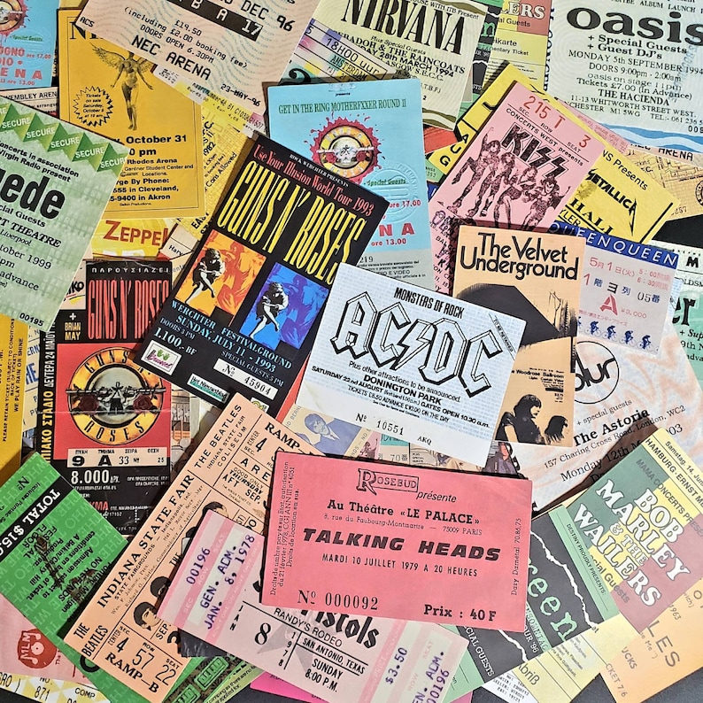 K&ouml;nnte beinhalten: Eine Sammlung von Vintage-Konzertkarten mit Bands wie Guns N' Roses, Nirvana, AC/DC, The Beatles, Talking Heads und Bob Marley. Die Tickets sind in verschiedenen Farben und zeigen Bandlogos, Daten und Veranstaltungsorte.