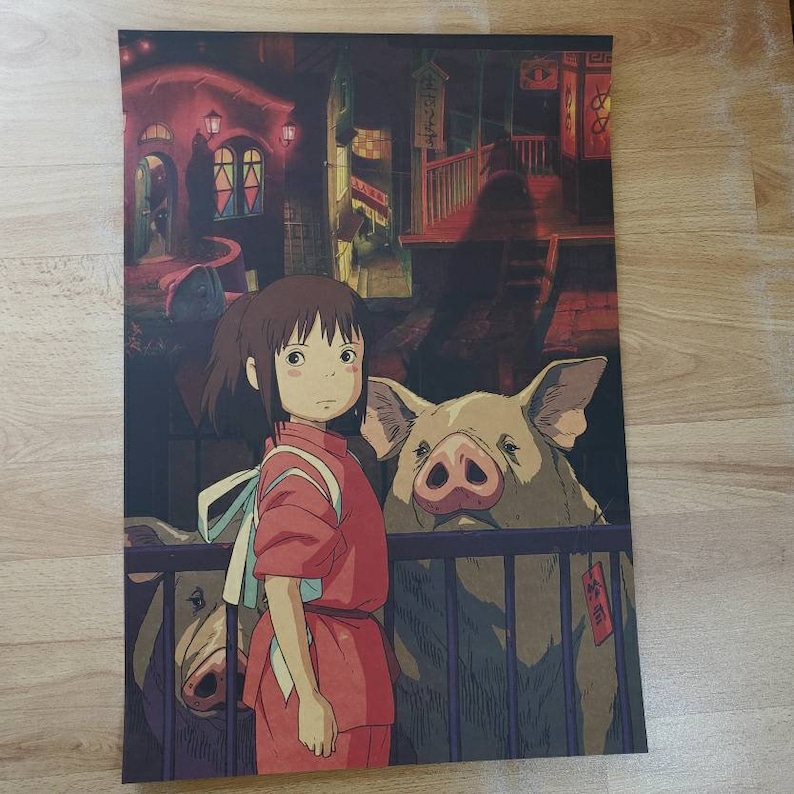 May include: A young girl with long brown hair wearing a red and white dress stands in front of two brown pigs in a pen. The girl is looking at the viewer. The pigs are looking at the girl. The background is a blurry image of a Japanese street scene.