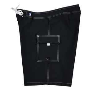 May include: Black swim trunks with a white drawstring and white stitching. The trunks have a single pocket on the right side.