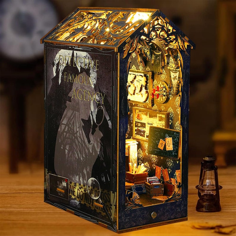 May include: A wooden miniature dollhouse with a lit interior, depicting a detective agency. The front of the house features a sign that reads "Detective Famous Agency". The interior is detailed with furniture, books, and other accessories.