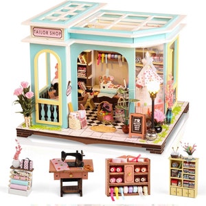 May include: A miniature dollhouse kit depicting a tailor shop with a blue and white exterior. The shop has a sign that reads "Tailor Shop". The interior is furnished with a sewing machine, fabric rolls, and other sewing supplies. The dollhouse is made of wood and comes with detailed instructions.