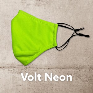 Peut inclure: Un masque facial vert n&eacute;on brillant avec des boucles d'oreille r&eacute;glables noires. Le masque est fait d'un tissu respirant et est con&ccedil;u pour &ecirc;tre confortable &agrave; porter.