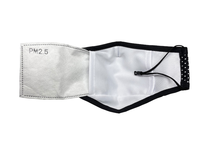 May include: A black face mask with white polka dots and a white filter insert labeled "PM2.5". The mask has an adjustable strap.