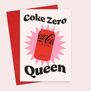 May include: A white card with the text "Coke Zero Queen" in black bold letters. A red Coca-Cola can with the text "Zero Sugar" is in the centre of the card, surrounded by a pink starburst.