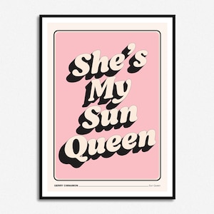 Peut inclure: Impression graphique rose et blanche avec le texte "She's My Sun Queen" dans une police de caractères de style rétro. L'impression est encadrée dans un cadre noir.