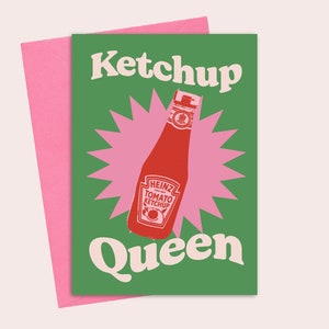 May include: A green card with the text "Ketchup Queen" in a retro font. A pink starburst surrounds a red Heinz tomato ketchup bottle.