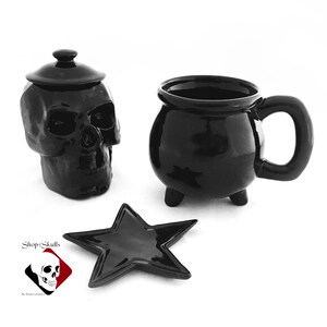 Pictured is a black cauldron mug that sits on 3 feet, a 5 point star tea bag holder or teaspoon rest, black skull sugar bowl with lid. Hand made in the USA. Shop for more amazing unique items on my website at www.ShopOfSkulls.com.