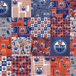 May include: A patchwork design featuring the Edmonton Oilers logo and team colours. The design incorporates various patterns, including the team logo, hockey sticks, and the word "Oilers" in a repeating pattern. The colour scheme includes blue, orange, and white.