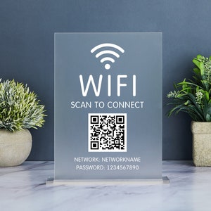 Può includere: Un cartello in acrilico trasparente con un simbolo WiFi bianco, il testo "WIFI SCAN TO CONNECT", un codice QR in bianco e nero e il testo "NETWORK: NETWORKNAME PASSWORD: 1234567890".