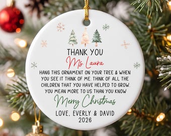 May include: A round white ceramic Christmas ornament featuring three small watercolor trees and snowflakes. The text reads: THANK YOU Ms. Laura, HANG THIS ORNAMENT ON YOUR TREE & WHEN YOU SEE IT THINK OF ME. THINK OF ALL THE CHILDREN THAT YOU HAVE HELPED TO GROW. YOU MEAN MORE TO US THAN YOU KNOW Merry Christmas LOVE, EVERLY & DAVID 2026.