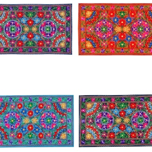 Könnte beinhalten: Vier farbige rechteckige bestickte Kissen mit einem Blumenmuster. Die Kissen haben einen dunkelblauen, roten, hellblauen und dunkelblauen Hintergrund.