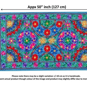 May include: A colorful embroidered wall tapestry with a blue background and a geometric pattern of circles and flowers. The tapestry is approximately 30 inches by 50 inches.