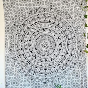 May include: Black and white tapestry featuring a large circular mandala design with elephants and floral patterns. The mandala is surrounded by a border of smaller geometric patterns.