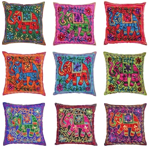 Pode incluir: Nove almofadas quadradas coloridas com elefantes bordados em várias cores e padrões. As almofadas têm um design floral e são decoradas com lantejoulas.