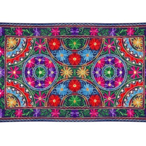 May include: A colorful embroidered tapestry with a repeating pattern of flowers and circles. The tapestry is navy blue with red, pink, yellow, green, and blue embroidery.