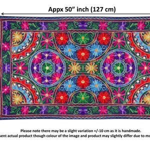 May include: A colorful, hand-stitched wall tapestry with a floral design. The tapestry is approximately 50 inches wide and 30 inches tall. It features a repeating pattern of flowers, circles, and geometric shapes in shades of red, blue, green, yellow, and purple.