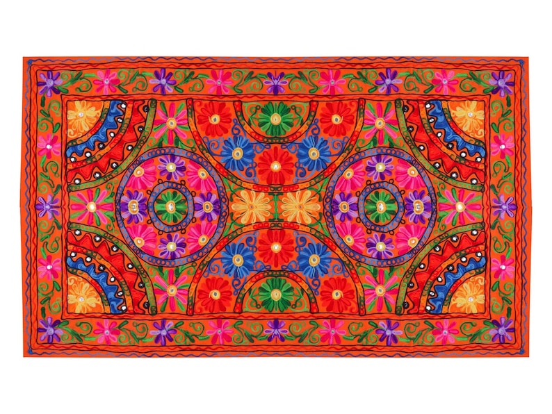 May include: A colorful embroidered throw pillow with a geometric pattern of circles and flowers in shades of red, orange, yellow, green, blue, and purple. The pillow is surrounded by a border of smaller flowers.