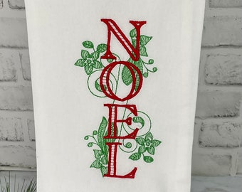 Puede incluir: Toalla de cocina blanca con letras bordadas en rojo que deletrean "NOEL" con detalles florales verdes.