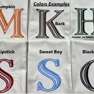 May include: Six white fabric squares featuring embroidered letters M, K, H, S, S, and C in various thread colors. The letters are labeled with color names: Pumpkin, Bark, Hunter, Lipstick, Sweet Boy, and Black, with the text Colors Examples.