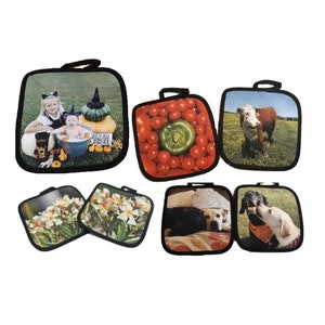 Op de afbeelding: Set van zes vierkante pottenlapjes met verschillende afbeeldingen erop gedrukt. De afbeeldingen omvatten een gezin in een Halloweenkostuum, een kom met tomaten en een groene paprika, een bruin-witte koe in een veld, twee witte bloemen en twee honden.