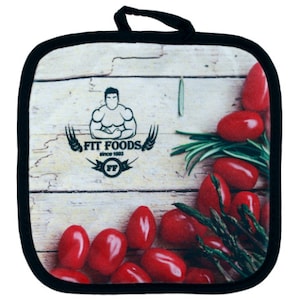 Puede incluir: Un posavasos negro y blanco con un fondo de madera. El posavasos presenta un logotipo para "Fit Foods" con un hombre musculoso y el texto "desde 1993". El posavasos tambi&eacute;n presenta tomates rojos, esp&aacute;rragos verdes y romero verde.