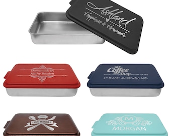 Puede incluir: Cuatro moldes para hornear de 23x33 cm con tapas. Las tapas están personalizadas con diferentes diseños y textos. Los moldes son plateados y las tapas son negras, rojas, azules y verde azulado.