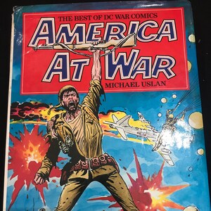 May include: A comic book cover featuring a soldier holding a rifle with a red, white, and blue American flag design. The cover is titled "America At War" and features a soldier in a jungle setting with explosions and tanks in the background.