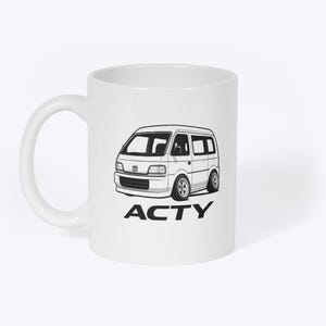 Könnte beinhalten: Weißer Keramikbecher mit einer Schwarz-Weiß-Illustration eines Honda Acty Vans. Der Van ist in einem Cartoon-Stil dargestellt, mit dem Wort "ACTY" darunter. Der Becher hat einen gebogenen Griff.