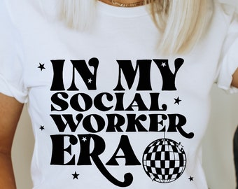 May include: White t-shirt with black text that reads "In My Social Worker Era" with a disco ball graphic.