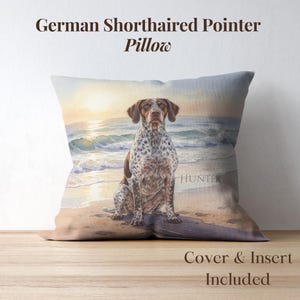 Könnte beinhalten: Quadratisches Kissen mit einem Aquarellgemälde eines Deutsch Kurzhaar Hundes am Strand. Der Hund hat braunes und weiß geflecktes Fell. Das Kissen hat den Text "German Shorthaired Pointer Pillow" und "Cover & Insert Included".