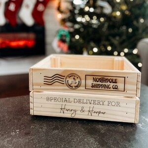 May include: A wooden crate with a "Northpole Shipping Co." logo and a "Santa's Reindeer Express" stamp. The crate is labeled "Special Delivery for Henry & Harper".