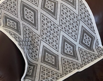 May include: A white and gray crocheted throw blanket with a geometric diamond pattern.