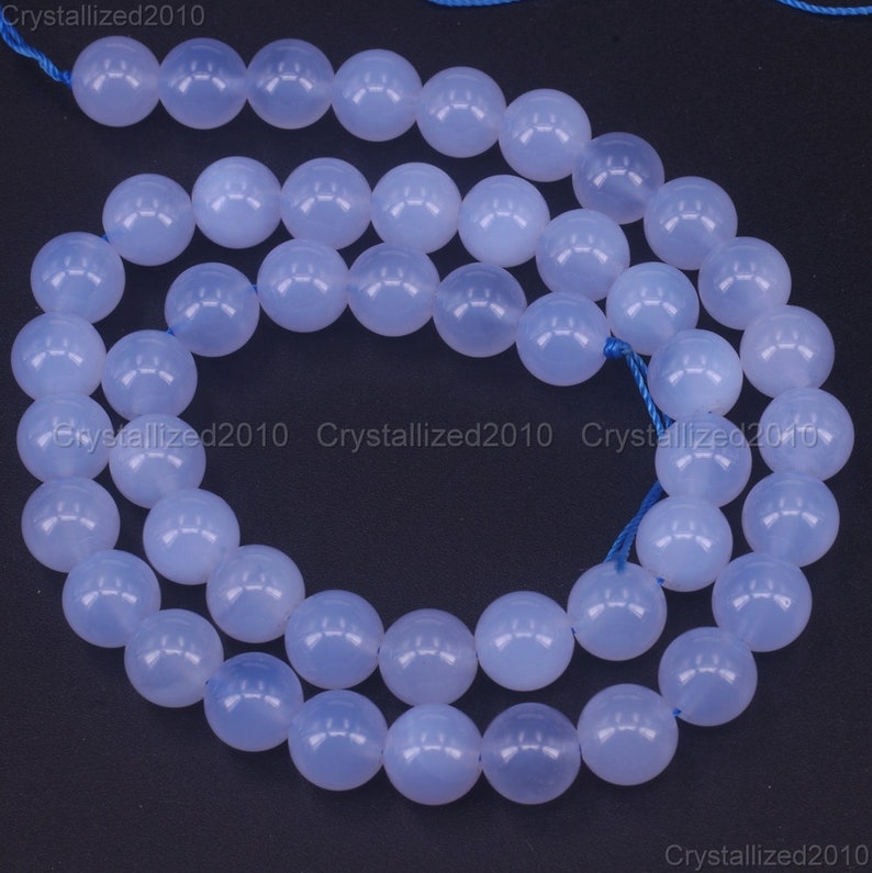 May include: A strand of light blue round beads, made of chalcedony, for jewelry making.