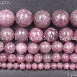 Puede incluir: Filas de cuentas de piedras preciosas rosas de varios tamaños. Las cuentas tienen una superficie lisa y pulida y una forma redonda consistente. El color es un rosa suave y polvoriento, con sutiles variaciones de tono.