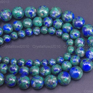 Peut inclure: Un brin de perles rondes en pierres précieuses bleues et vertes. Les perles ont un aspect marbré et moucheté.