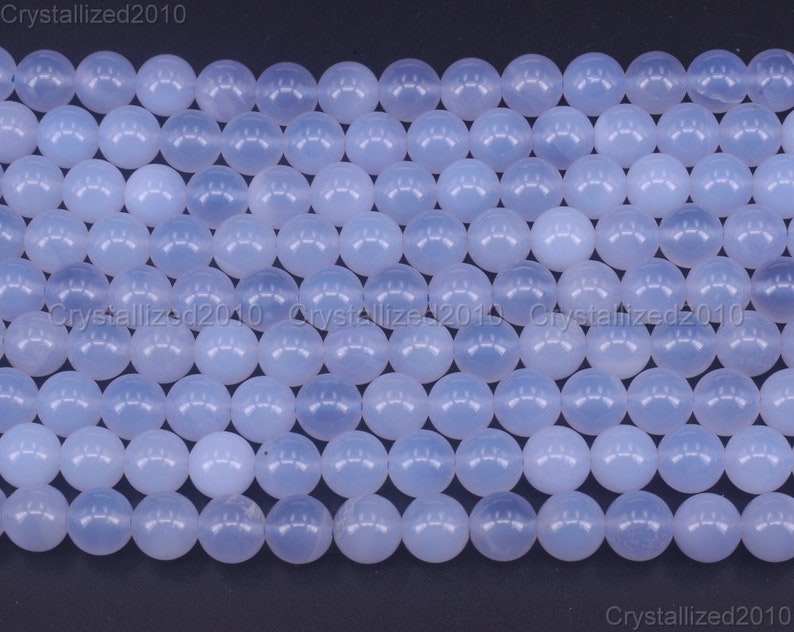 May include: A strand of light blue round beads made of chalcedony. The beads are smooth and polished.
