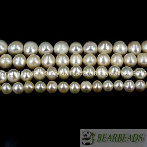 May include: A strand of off-white pearl beads. The beads are round and have a slight iridescent sheen.