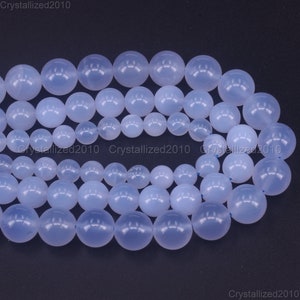 May include: A strand of light blue round gemstone beads. The beads are smooth and polished, and they have a translucent appearance.