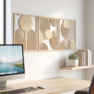 May include: Three rectangular light-colored wooden wall panels featuring intricate laser-cut geometric designs. Each panel displays a unique arrangement of concentric circles, semi-circles, and straight lines, creating a cohesive set of wall art.