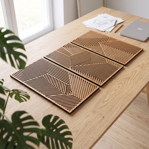 May include: Three rectangular wooden wall art panels featuring intricate, laser-cut geometric patterns with parallel lines arranged in angular, intersecting formations. The natural light-brown wood grain is visible across the flat surfaces.